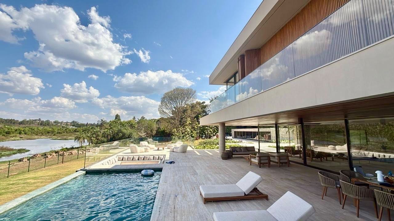 Terraço com piscina, espreguiçadeiras e vista para o lago